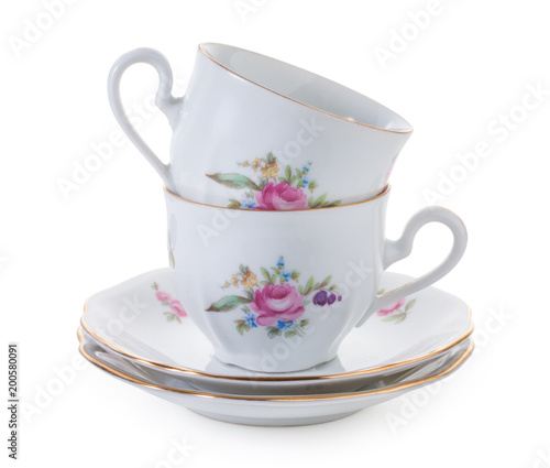 Pair of vintage czech empty porcelain cups for coffee on saucers, old style rich decorated, isolated on a white background.