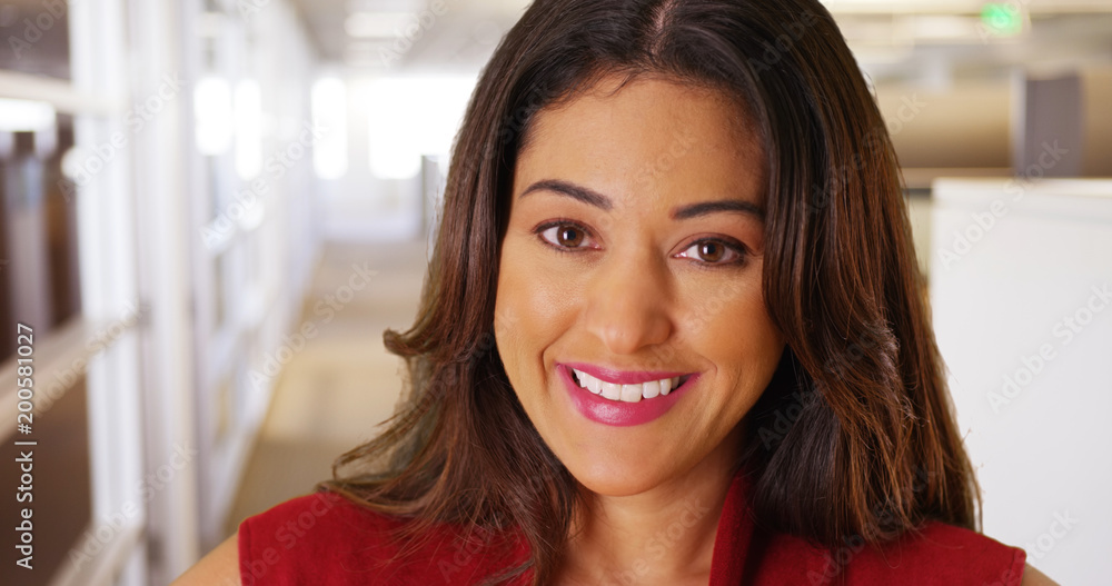Close up of cheerful businesswoman smiling at camera in modern office building Close up of cheerful businesswoman smiling at camera in modern office building