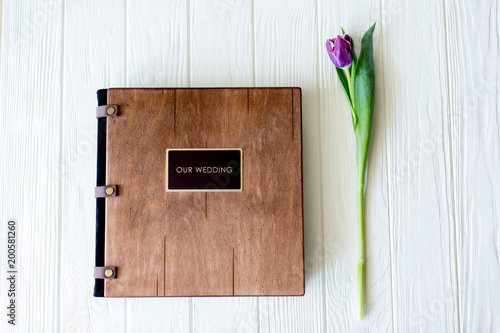 Wood wedding photo book. Happy young couple in love. Bride and groom walking of wedding day.