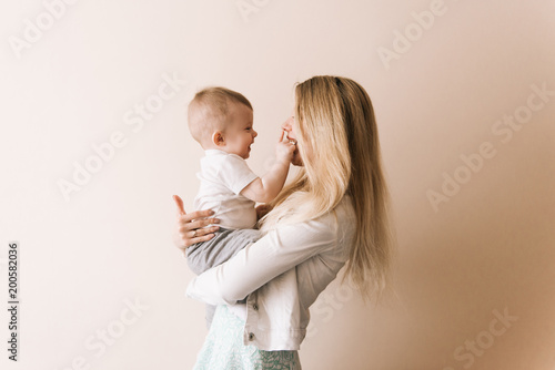Mother playing with baby boy, happy family having fun indoor, cheerful sweet kid portrait, mom and child, healthy toddler, lifting throwing carrying holding up game