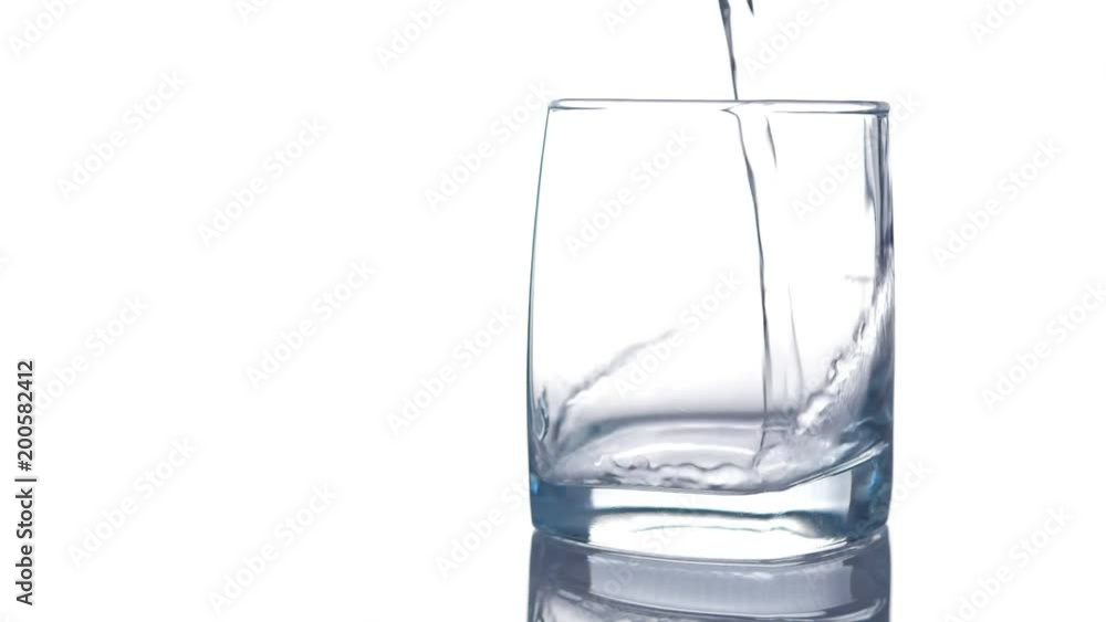 Pouring clean water into the glass. Closeup on white background Pouring clean water into the glass. Closeup on white background