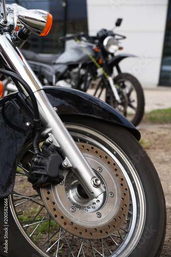 Two motorcycles. Close-up of the front wheel  brake disc  shock absorbers.