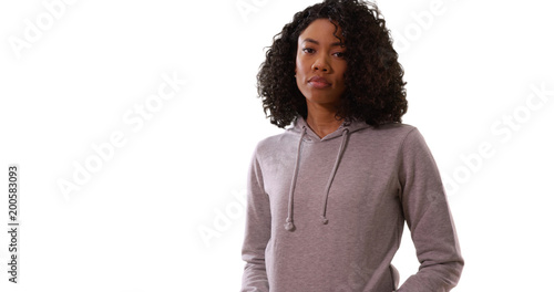 Stern black female posing seriously in gray hoodie on solid white background