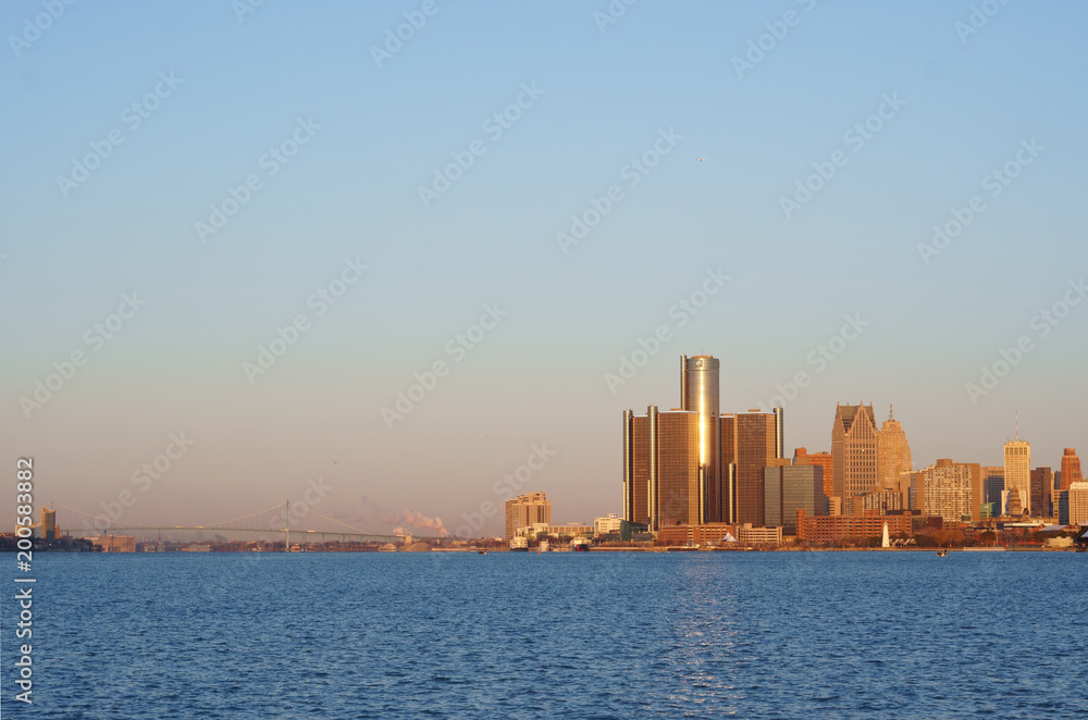 Downtown Detroit view from Belle-Isle during sunrise with view on Bridge to Windsor, Ontario, Canada. The morning sun reflect on GM towers.