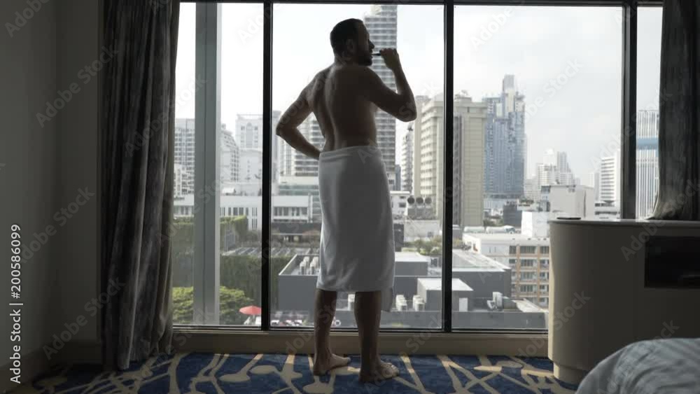 Man wearing towel after having taken shower and brushing his teeth
Man wearing towel after having taken shower and brushing his teeth