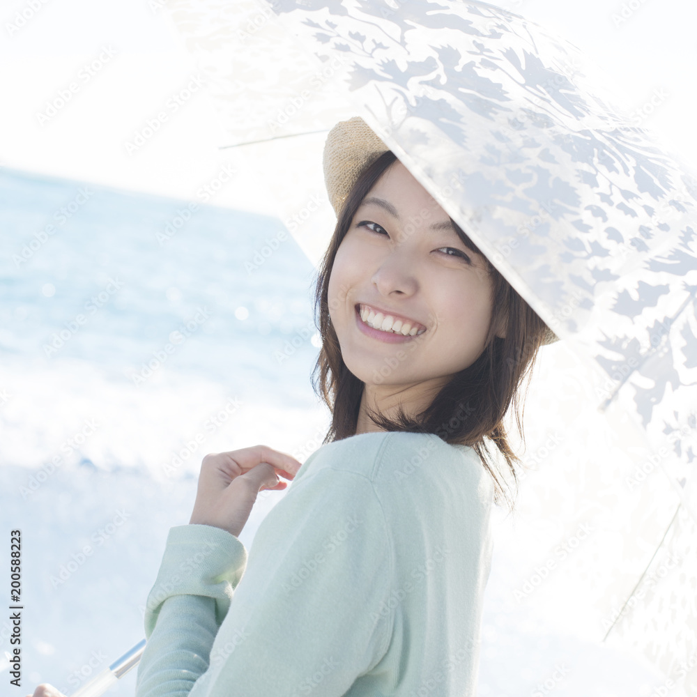 海で日傘をさし微笑む女性 Stock 写真 Adobe Stock