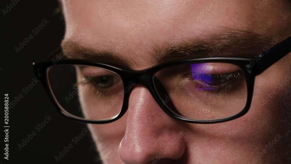 A close-up of a young man's face against a black background. Macro shot A close-up of a young man's face against a black background. Macro shot