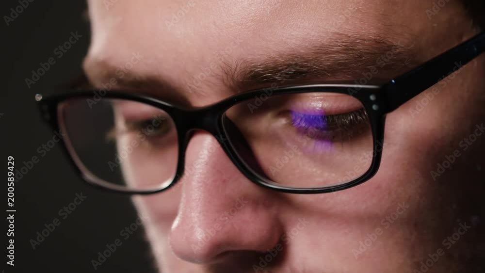 A close-up of a young man's face against a black background. Macro shot A close-up of a young man's face against a black background. Macro shot