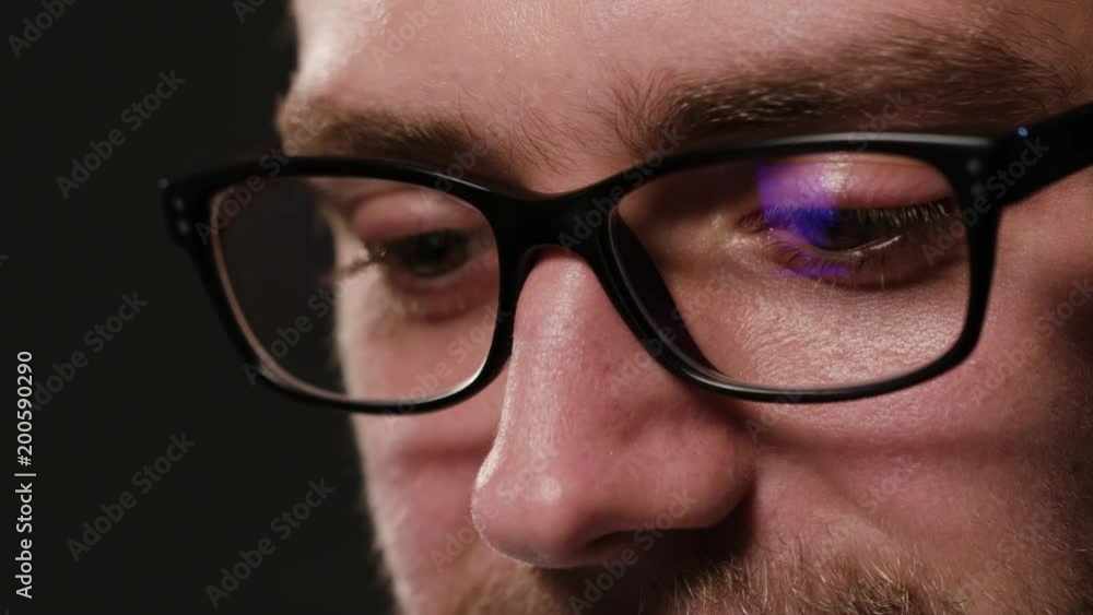 A close-up of a young man's face against a black background. Macro shot A close-up of a young man's face against a black background. Macro shot