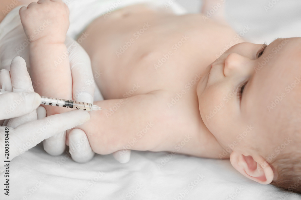 Doctor vaccinating baby in clinic Doctor vaccinating baby in clinic