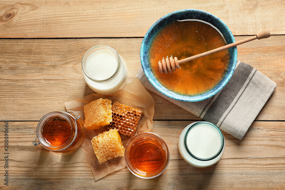 Composition with milk and honey on wooden background, top view Composition with milk and honey on wooden background, top view