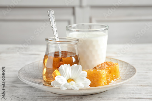 Beautiful composition with milk and honey on wooden table