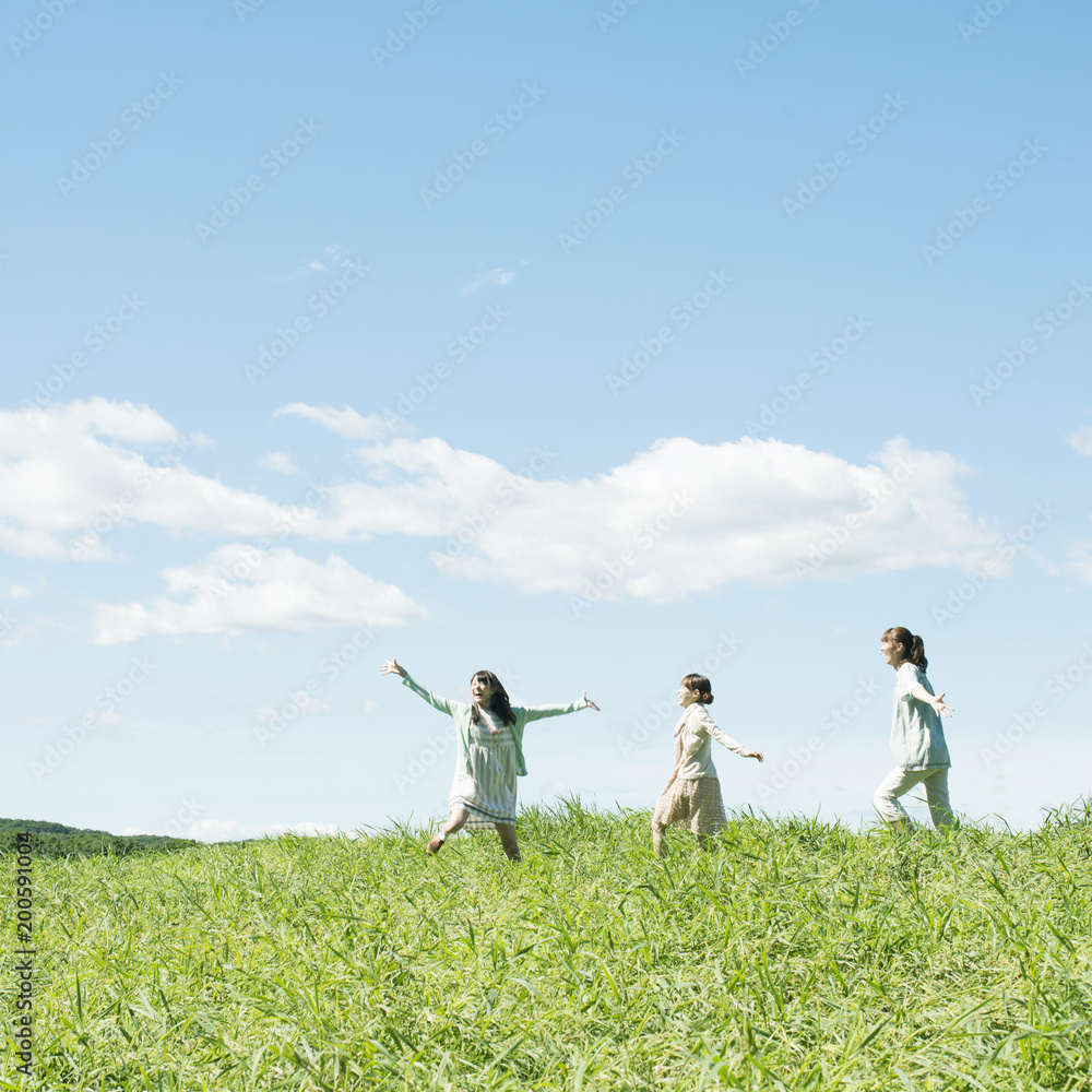 草原を走る3人の女性