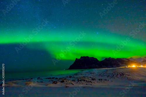 Beautiful picture of massive green vibrant Aurora Borealis, also know as Northern Lights in the night sky over Lofoten Islands