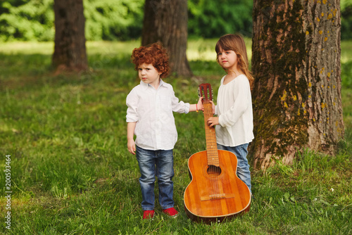boy and girl playing guitar in summer park © Aliaksei Lasevich