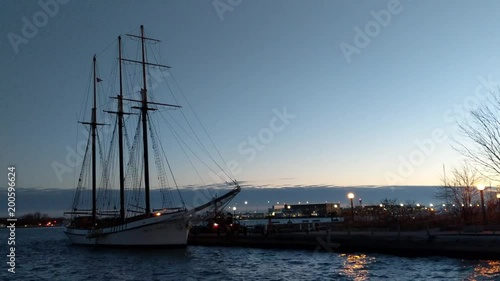 Three mast schooner moored in the Toronto Harbourfront at dusk with the islands airport in the background photo