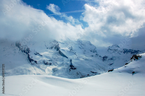 High mountains under snow with clouds and blue skies in Switzerland 