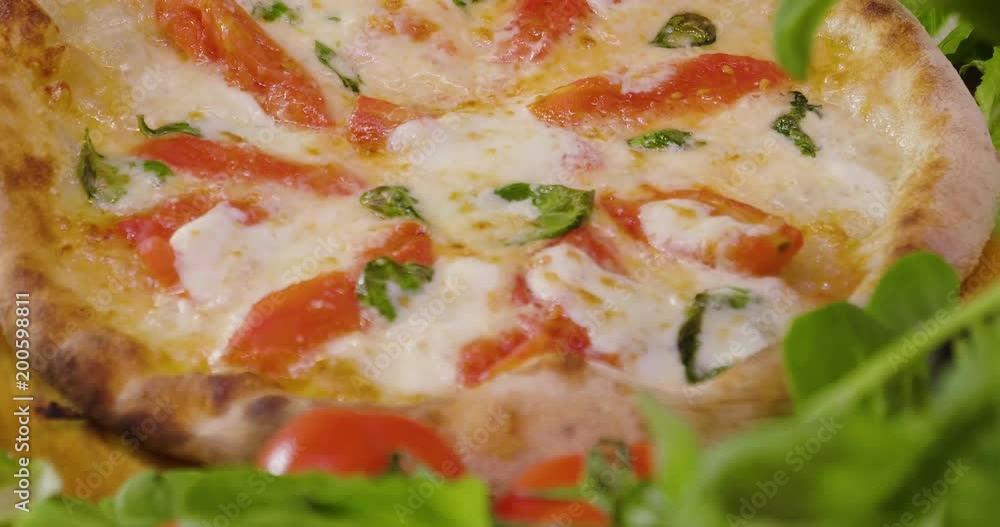 Close up of a pizza chef's hands filling a pizza with high quality Italian gastronomic ingredients, such as: ham, various cheeses, tomatoes and fresh and bio vegetables Close up of a pizza chef's hands filling a pizza with high quality Italian gastronomic ingredients, such as: ham, various cheeses, tomatoes and fresh and bio vegetables