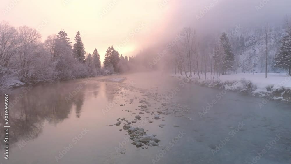 Flying low over the Soca River as the sun lights up the foggy mist in winter landscape in Slovenia. Flying low over the Soca River as the sun lights up the foggy mist in winter landscape in Slovenia.