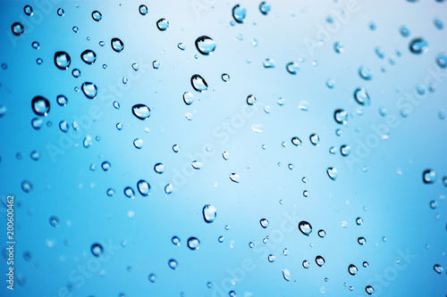 Drops of rain on glass with blue background