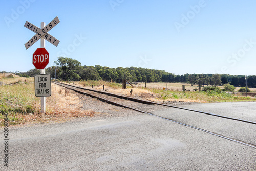 red, black and white Stop, Look For Trains, Railway Crossing warning signs at railway tracks in rural Australia