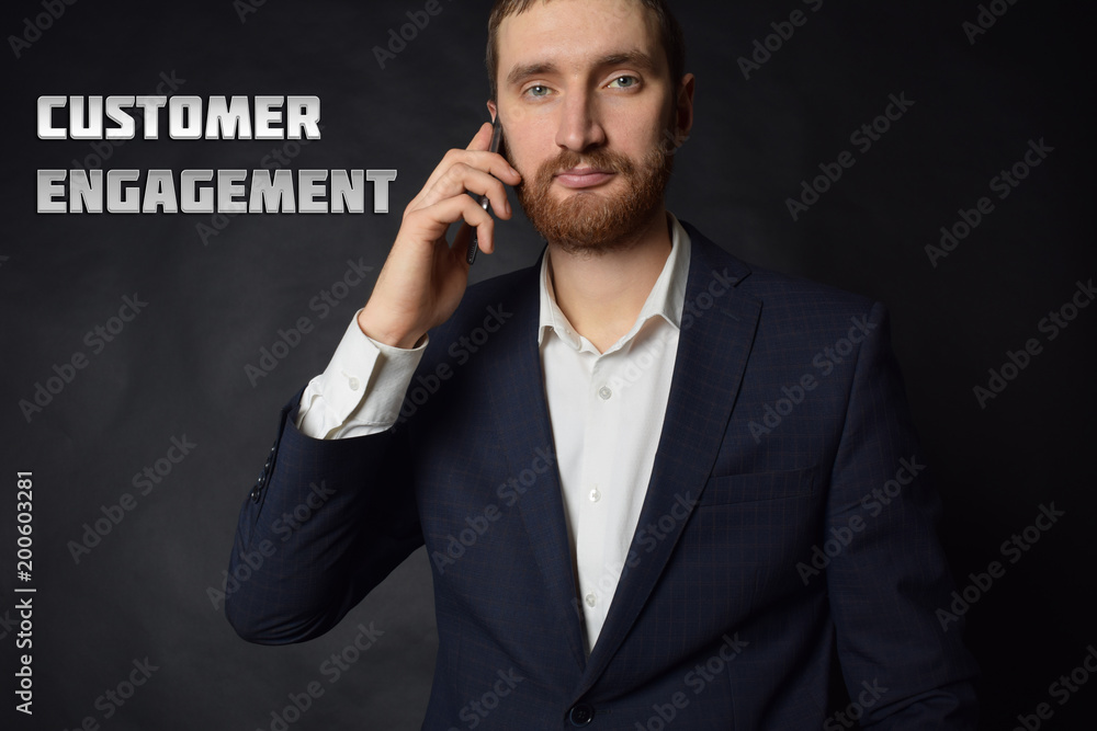 A businessman shows an inscription:CUSTOMER ENGAGEMENT A businessman shows an inscription:CUSTOMER ENGAGEMENT