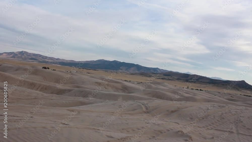 Dirt bike jumps over sand dunes. The dunes are a popular place for recreation in Utah. Dirt bike jumps over sand dunes. The dunes are a popular place for recreation in Utah.