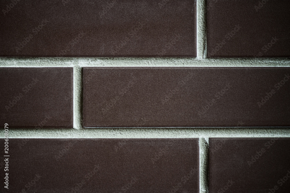 Fototapeta premium background of a brick dark wall, tile texture with a smooth pattern.