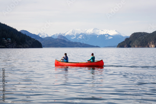 Couple friends canoeing on a wooden canoe during a sunny day. Taken in Harrison Lake  East of Vancouver  British Columbia  Canada.