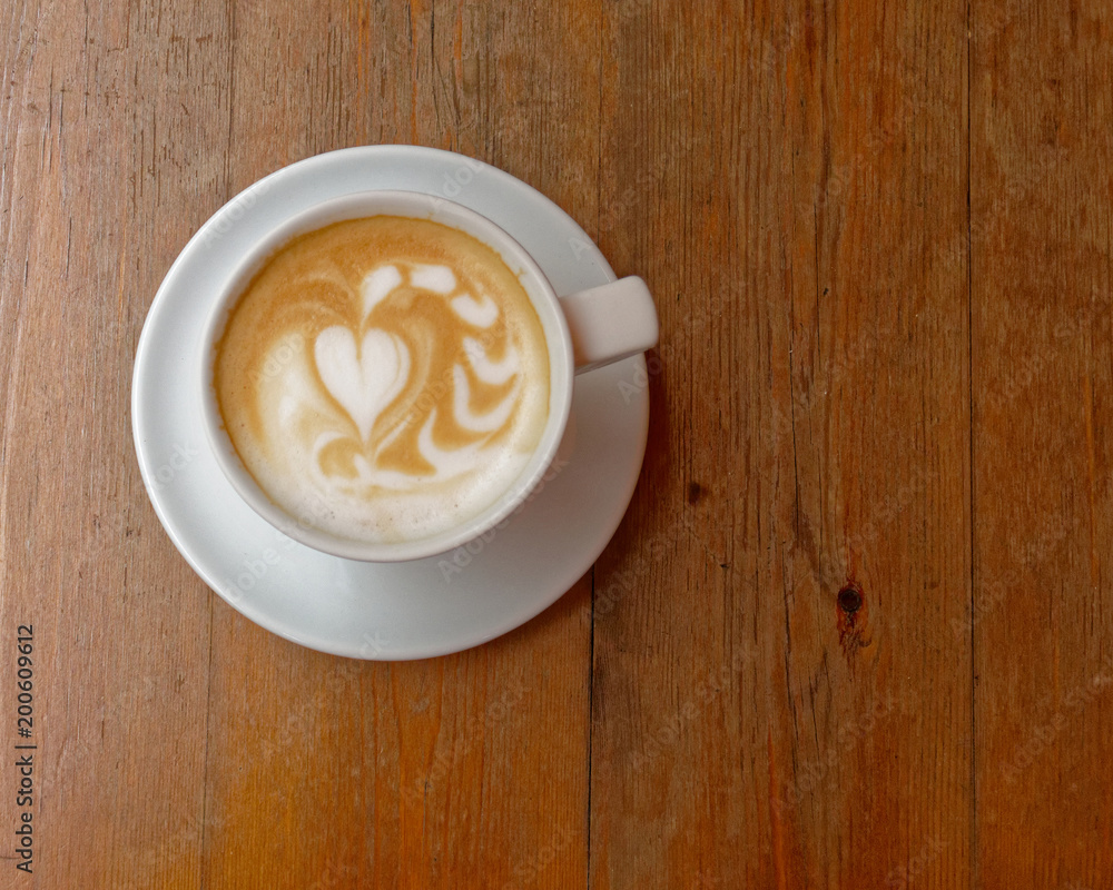 hot caffe latte cup on brown wood background, top view hot caffe latte cup on brown wood background, top view
