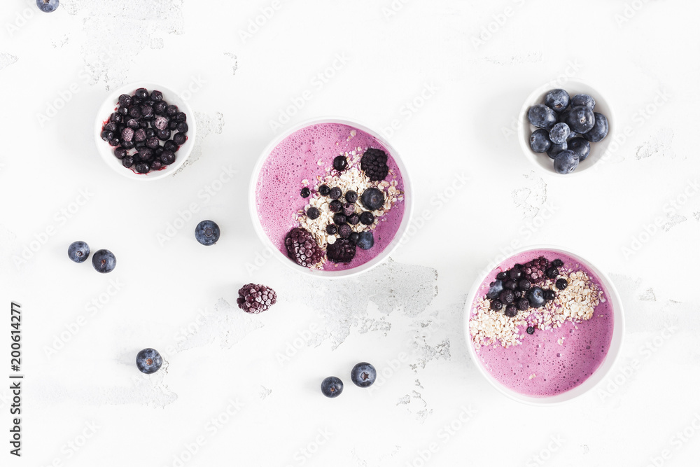 Breakfast with muesli, acai blueberry smoothie, fruits on white background. Healthy food concept. Flat lay, top view