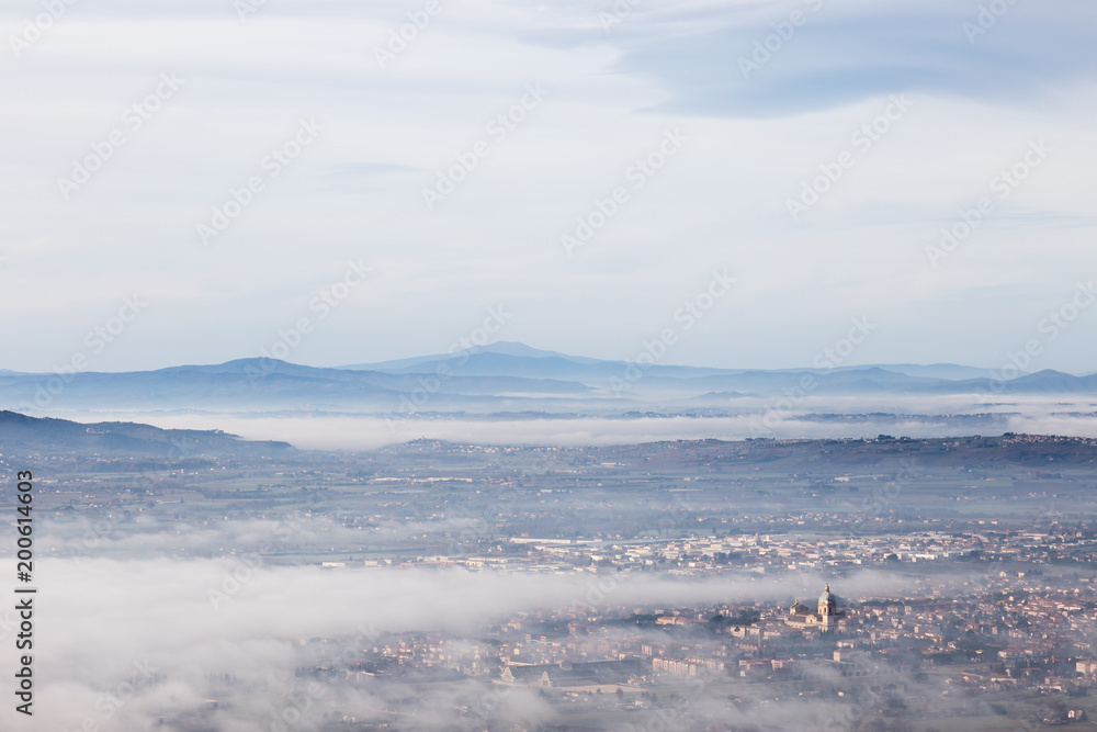 Beautiful aerial view of Santa Maria degli Angeli town (Assisi, Umbria), partially covered by mist and fog Beautiful aerial view of Santa Maria degli Angeli town (Assisi, Umbria), partially covered by mist and fog