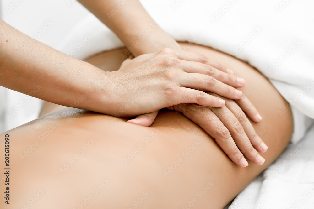 Fotografering, Billede Young woman receiving a back massage in a spa  center. på Europosters.dk