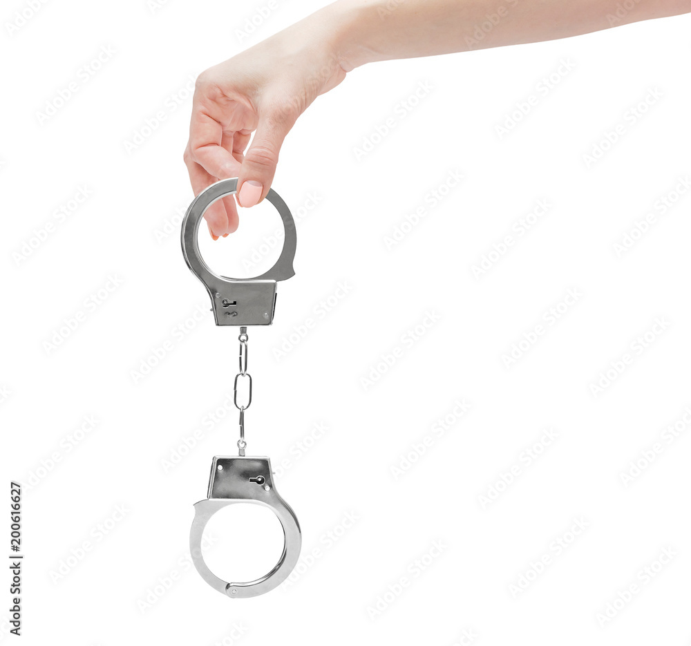 Female's hand holding handcuffs. Isolated on white. Female's hand holding handcuffs. Isolated on white.