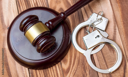 Judge's gavel with handcuffs on the table. Top view. Crime and law concept.