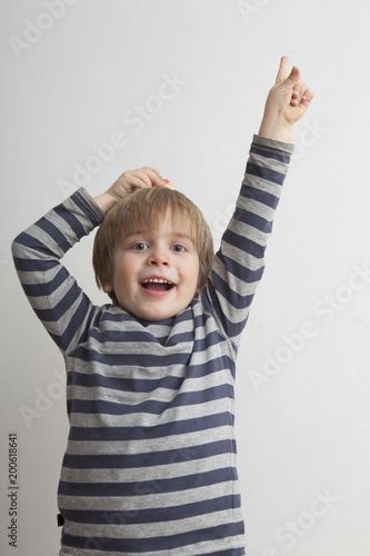 Niño (5 años) alzando el dedo índice de la mano. photo
