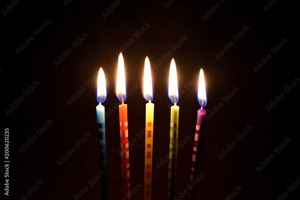 Cake candles on a dark background stock images. Colored cake candles.  Burning cake candles. Birthday background images. Party candles on a black  background foto de Stock | Adobe Stock
