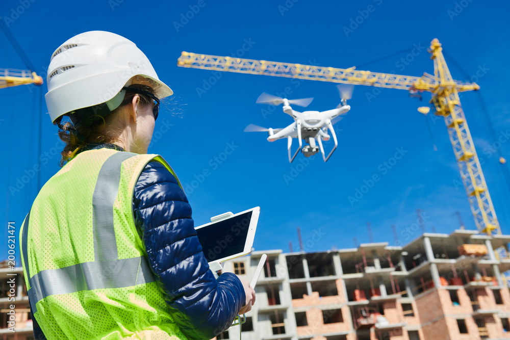 Drone inspection. Operator inspecting construction building site flying  with drone Photos | Adobe Stock