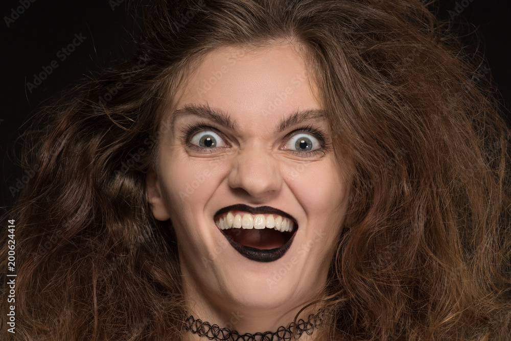 Beautiful girl witch with curly hair on black background for holiday halloween Beautiful girl witch with curly hair on black background for holiday halloween