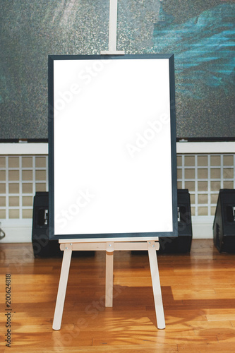 Mock up - painting on an easel at an exhibition or auction. Vertical photo.