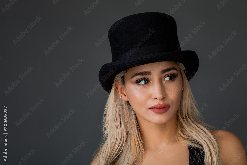 Beautiful and lovely woman portrait wearing top hat and looking aside Beautiful and lovely woman portrait wearing top hat and looking aside