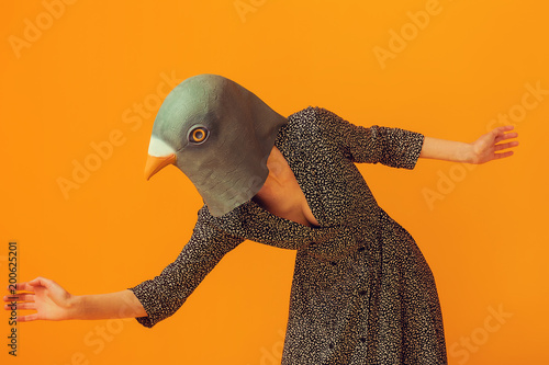 Tableau sur toile Woman wearing pigeon mask and going to run