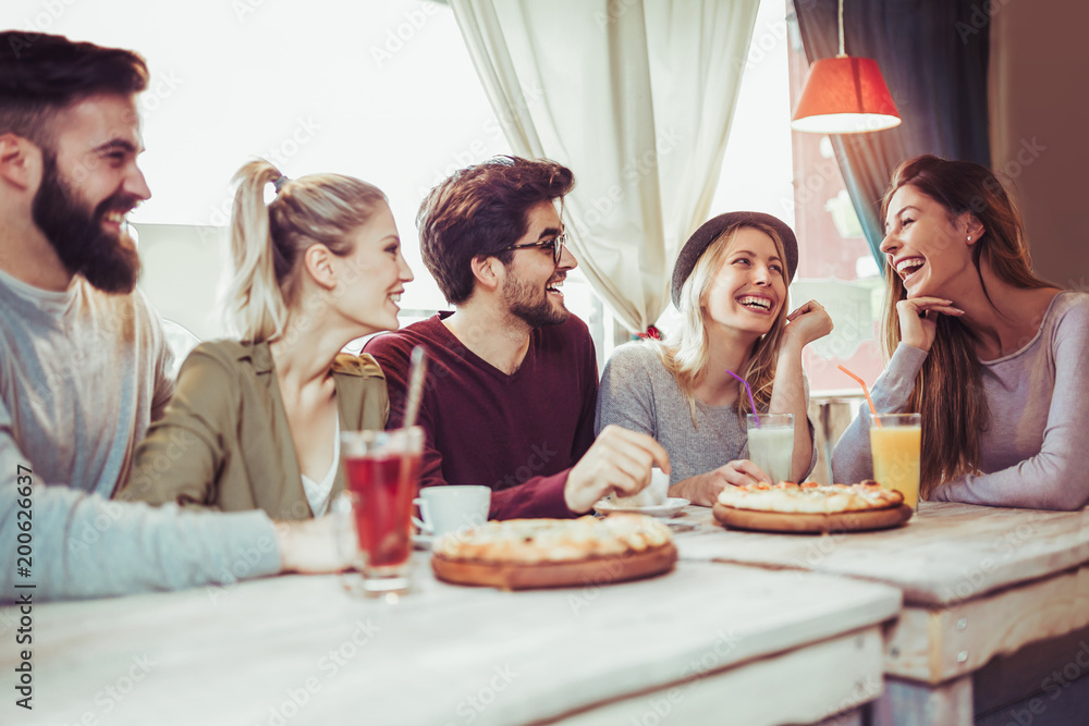 Young friends sharing pizza in a indoor cafe Young friends sharing pizza in a indoor cafe