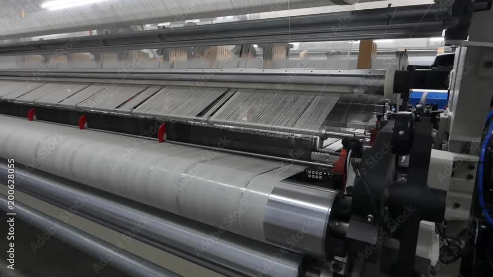 weaving loom at a textile factory, closeup. industrial fabric production line. the camera is stationary weaving loom at a textile factory, closeup. industrial fabric production line. the camera is stationary