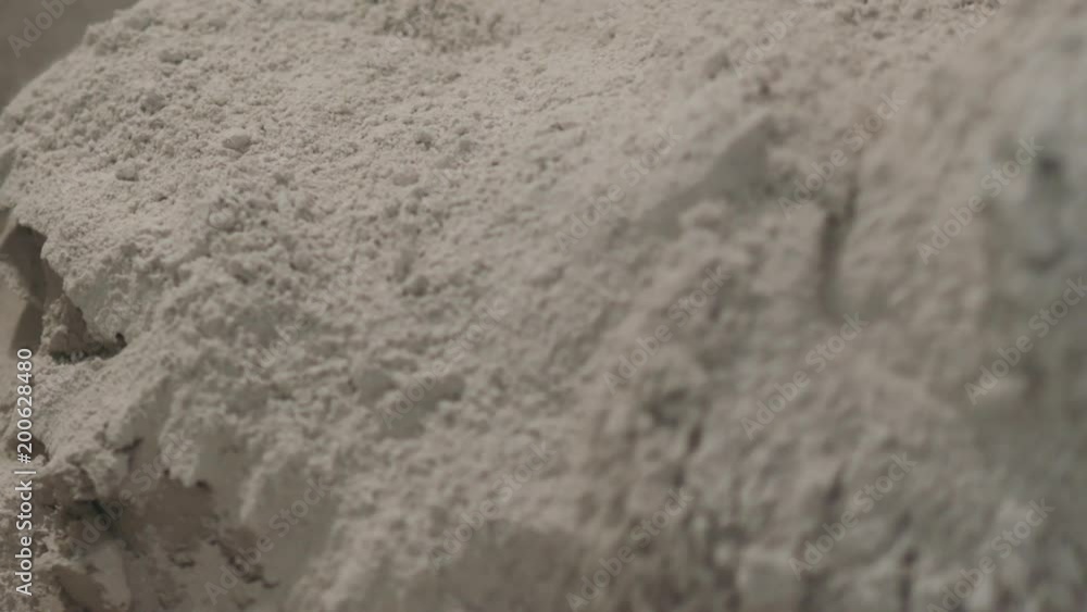 Slow motion handheld shot of pouring dry concrete plaaster into bucket Slow motion handheld shot of pouring dry concrete plaaster into bucket