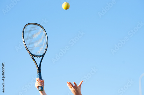 Tennis racket in hand and ball 