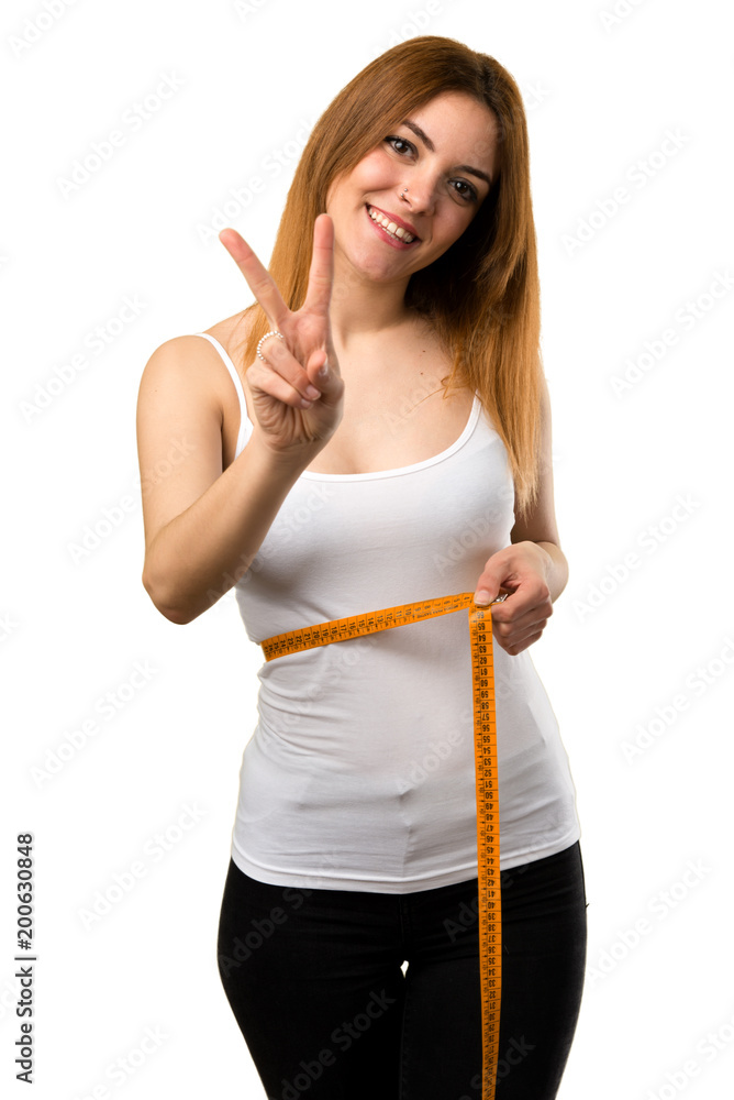 Slim woman with tape measure making victory gesture Slim woman with tape measure making victory gesture