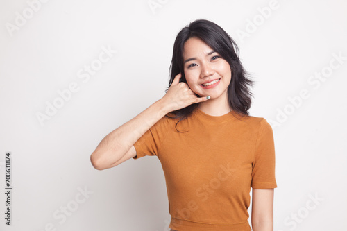 Young Asian woman show with phone gesture. © halfbottle