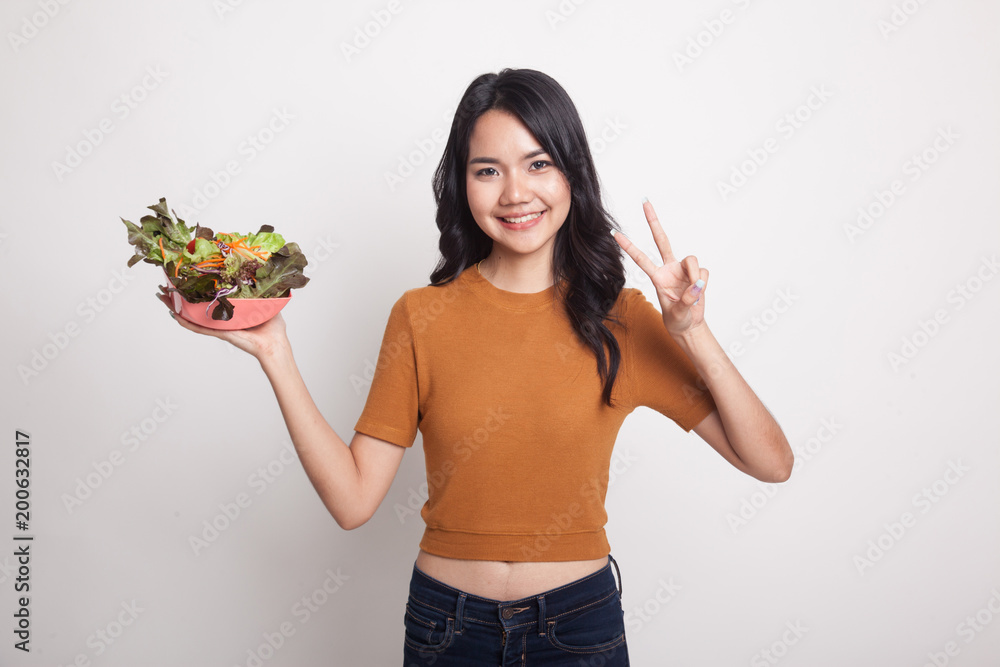 Healthy Asian woman show victory sign with salad. Healthy Asian woman show victory sign with salad.