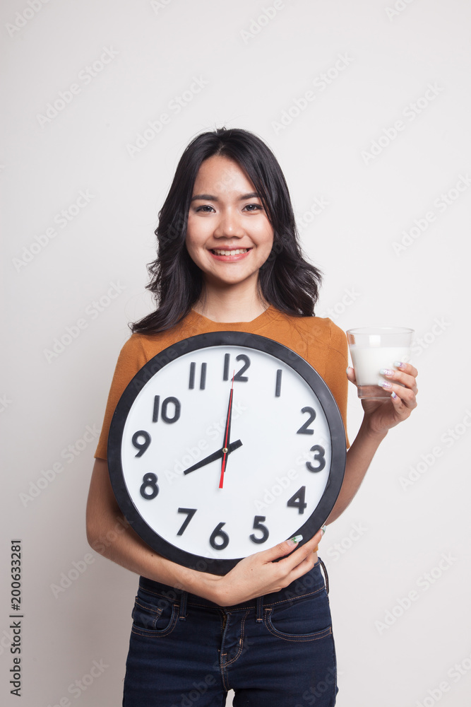 Healthy Asian woman drinking glass of milk hold clock. Healthy Asian woman drinking glass of milk hold clock.
